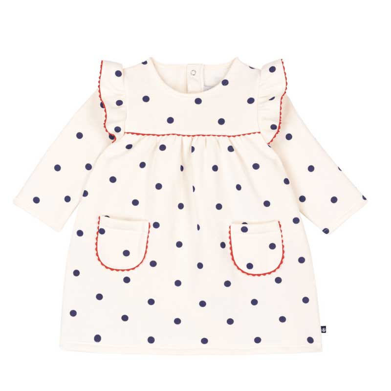 Delizioso abito a maniche lunghe decorato con simpatici pois blu su sfondo bianco, arricchito da ...