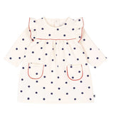Abito bianco a maniche lunghe con pois blu e bordi rossi sulle maniche e tasche