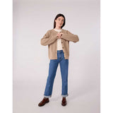 Cardigan beige con bottoni in finto corno, girocollo e taglio dritto.